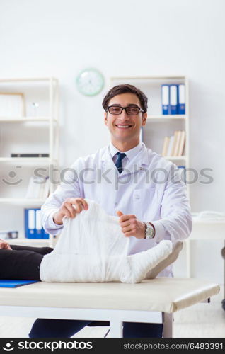 Doctor examining patient with broken leg