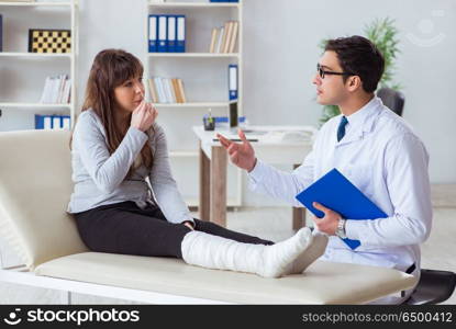 Doctor examining patient with broken leg