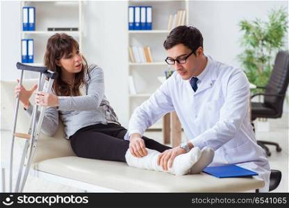 Doctor examining patient with broken leg