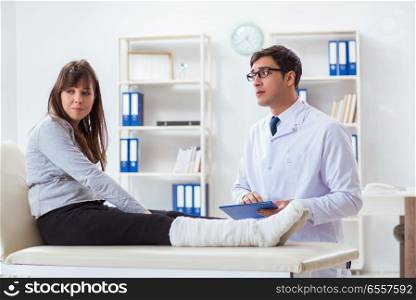 Doctor examining patient with broken leg