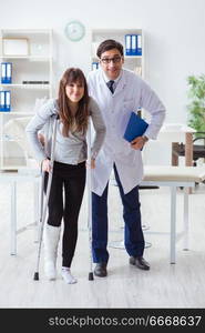 Doctor examining patient with broken leg