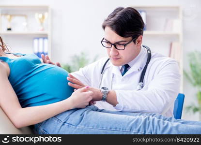 Doctor examining pregnant female patient in hospital