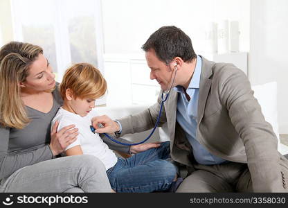 Doctor examining sick little boy