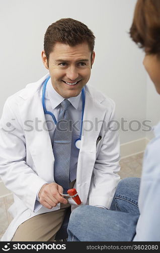 Doctor examining young patient with reflex hammer