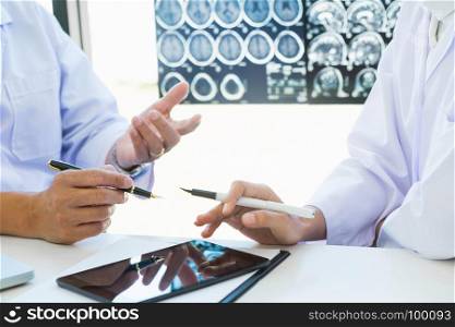 Doctor explaining consultant with x-ray films in consulting room