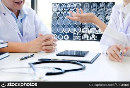 Doctor explaining consultant with x-ray films in consulting room