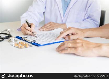 Doctor explaining for patient and showing medical records informations and diagnosis patient symptoms in a consultation and medical insurance concept