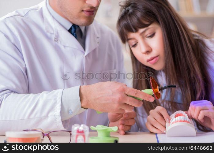 Doctor explaining to assistant how to use ultraviolet gun