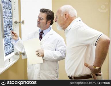Doctor explains a CT scan of the spine to his senior patient.