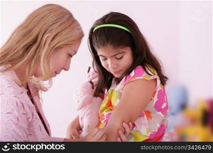 Doctor give injection to girl?s arm, focus on the little girl.