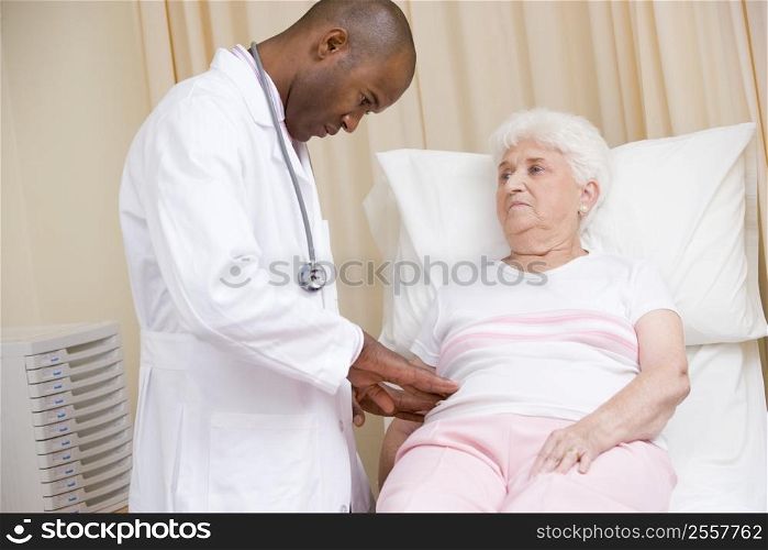 Doctor giving checkup to woman in exam room