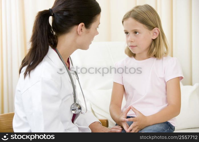 Doctor giving checkup to young girl in exam room