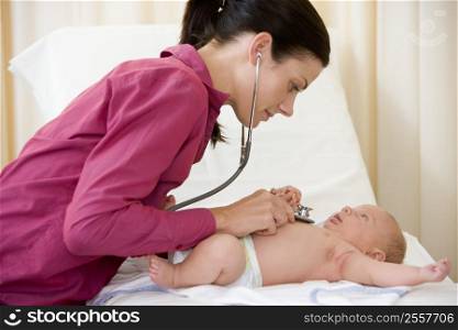 Doctor giving checkup with stethoscope to baby in exam room