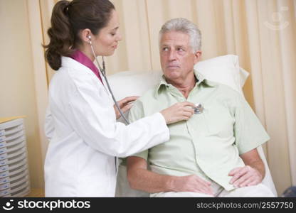 Doctor giving checkup with stethoscope to man in exam room