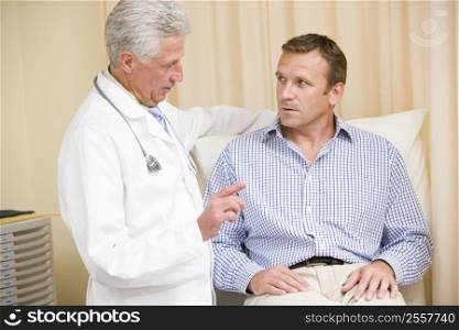 Doctor giving man checkup in exam room