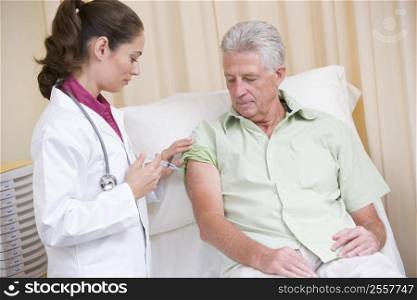 Doctor giving man needle in exam room