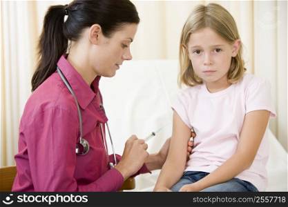 Doctor giving needle to young girl in exam room