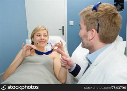 doctor giving patient protective glasses for medical treatment