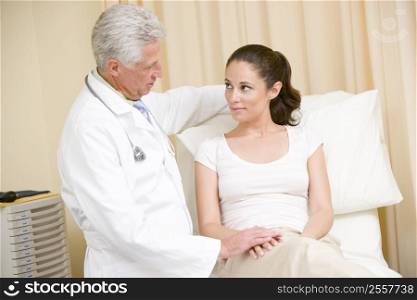 Doctor giving woman checkup in exam room