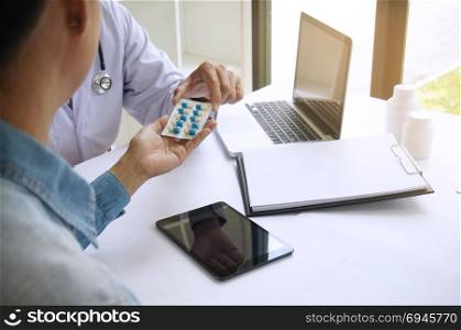 Doctor hand holding pack of different tablet blisters for patient. prescribe medicament. disease healing concept.