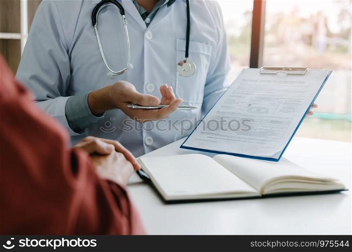 Doctor hand holding pen and talking to the patient about medication and treatment.
