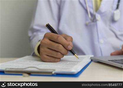 Doctor hand holding pen write and paperwork document patient treatment on clipboard.Business health care concept.