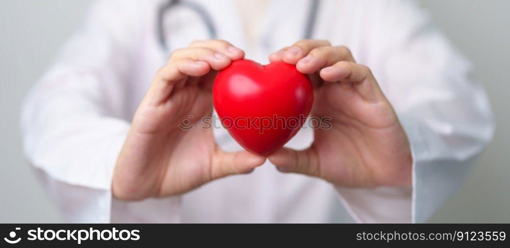 Doctor hand holding red heart shape in hospital. love, donor, world heart day, world health day, CSR donation and Insurance concepts