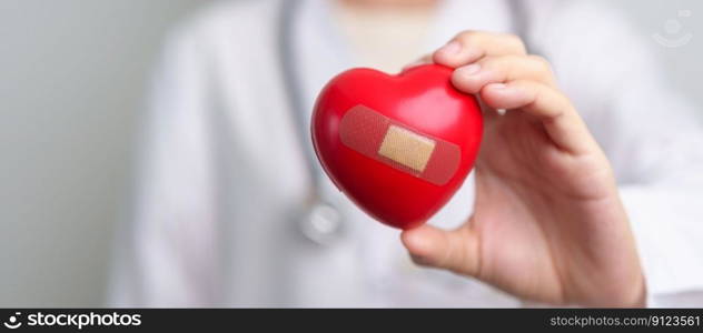 Doctor hand holding red heart shape in hospital. love, donor, world heart day, world health day, CSR donation and Insurance concepts