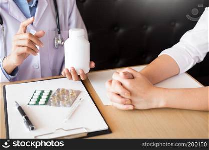 doctor hand holding tablet of drug and explain to patient in hospital room.