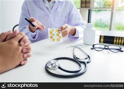 doctor hand holding tablet of drug and explain to patient in hospital room