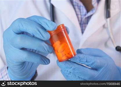 doctor hand in protective glass holding pill container.. doctor hand in protective glass holding pill container