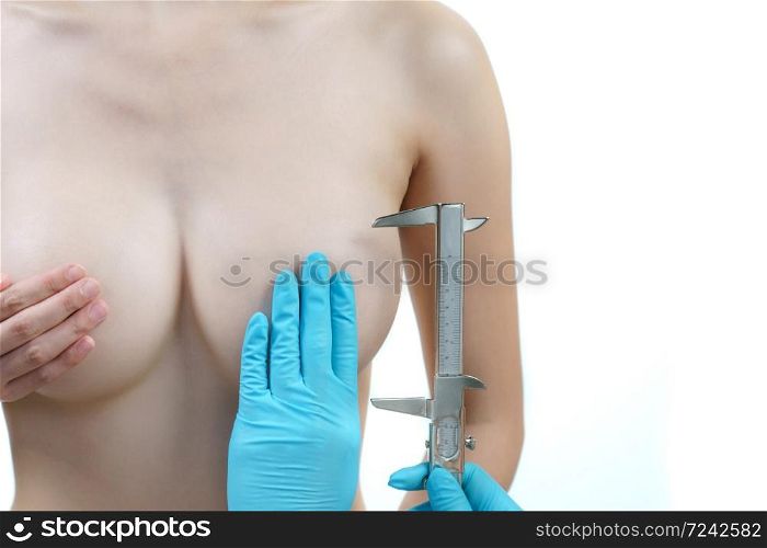 Doctor hand measurement woman breast with caliper, breast implant surgery concept.