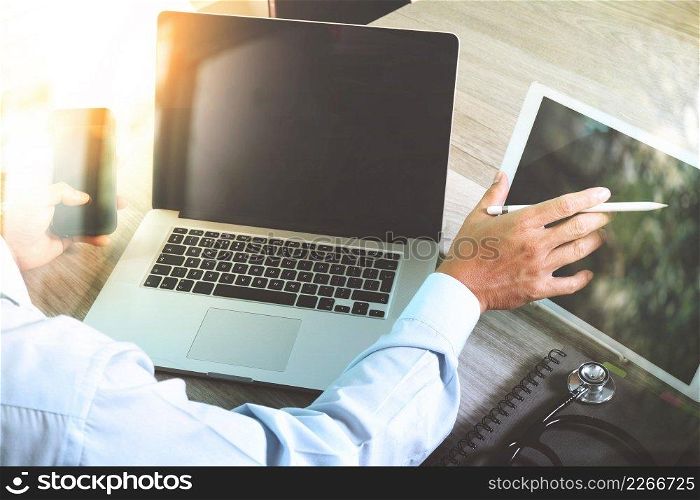 doctor hand working with modern digital tablet and laptop computer with smart phone as medical network concept