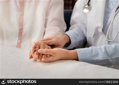 Doctor hands together holding senior woman patient