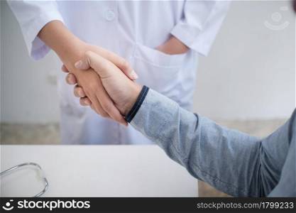 Doctor healthcare. Professional medical doctor in white uniform gown coat interview consulting patient reassuring his male patient helping hand concept
