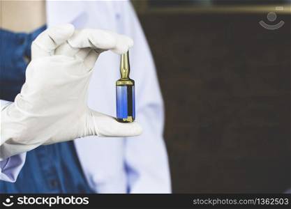 Doctor holding a vaccine ampoule bottle in his hand,Coronavirus treatment concept,Covid-19.