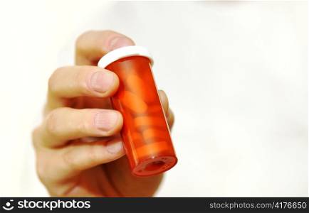 doctor holding bottle of prescription pills