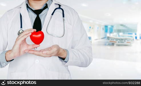 Doctor holding heart on background of Hospital ward