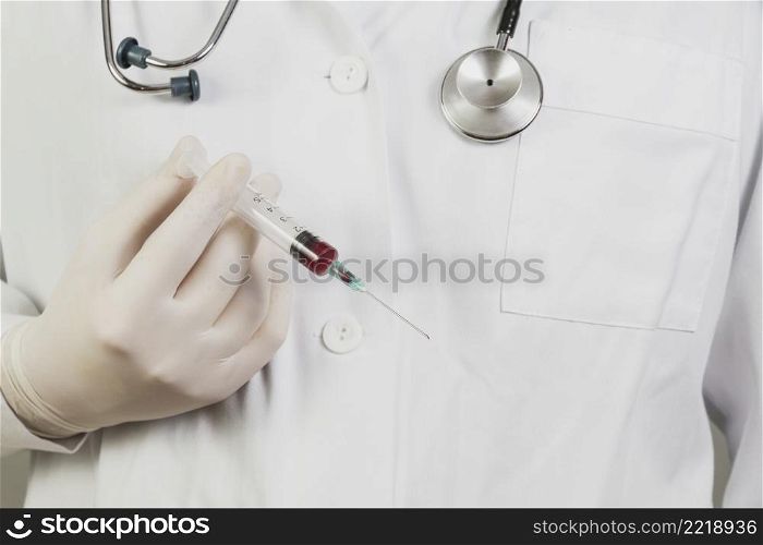 doctor holding needle with blood