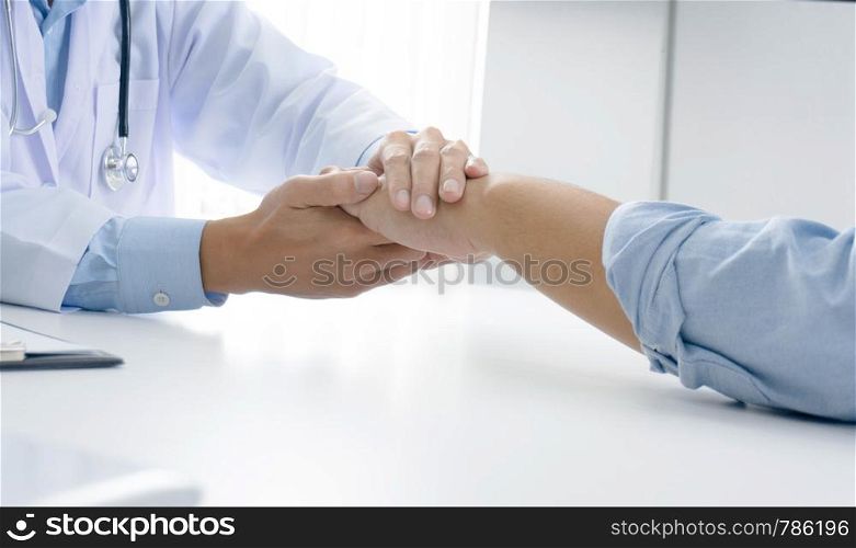 Doctor holding patient's hand, and reassuring his male patient helping hand concept