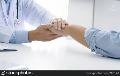 Doctor holding patient's hand, and reassuring his male patient helping hand concept