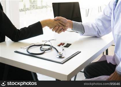 Doctor holding patient's hand, and reassuring his male patient helping hand concept.