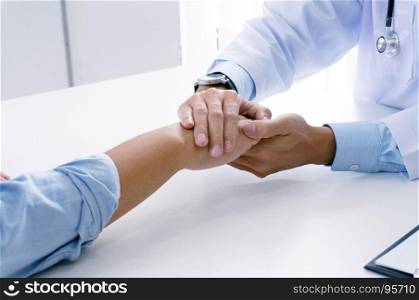 Doctor holding patient's hand, and reassuring his male patient helping hand concept
