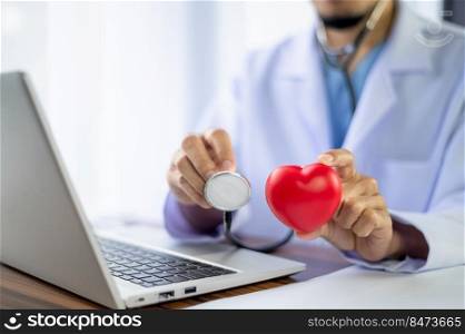 Doctor holding red heart in hospital office. Medical health care and doctor staff service clinic concept.