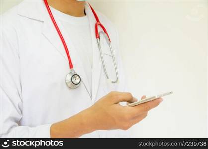 doctor holding smartphone on white background, focus on stethoscope