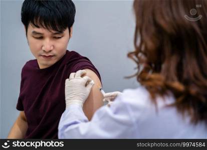 doctor holding syringe and using a cotton before make injection to patient. Covid-19 or coronavirus vaccine
