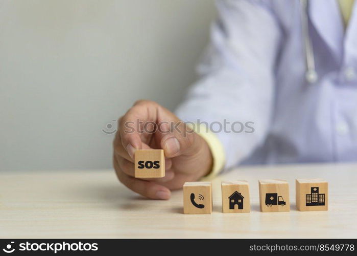 Doctor holding wood cube block sos icon health care business concept on desk.