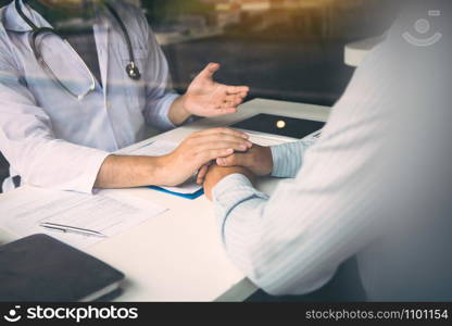 Doctor holds hands and leaves comforting counselors to patient.