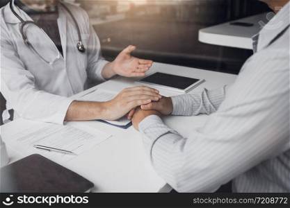 Doctor holds hands and leaves comforting counselors to patient.