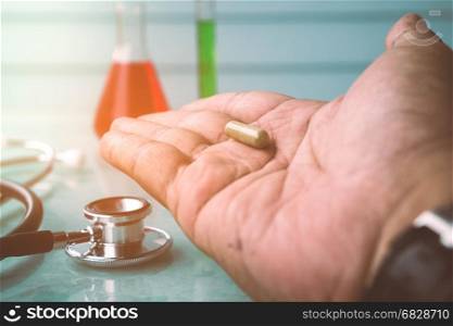 Doctor holds in hands capsule. Take painkillers . Medical treatment concept. Healthcare. Medical drugs.